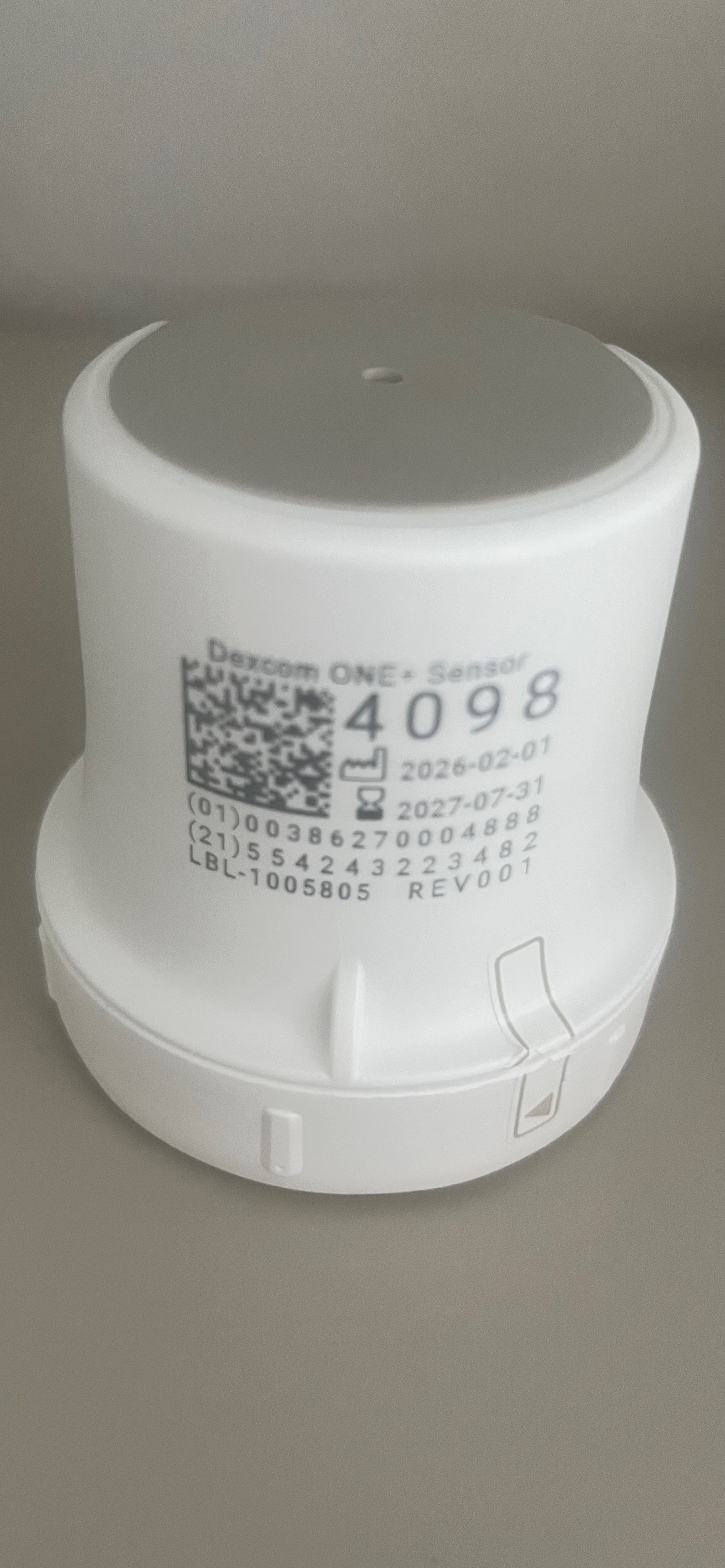 Photo of a Dexcom One+ sensor applicator showing the QR co
de and numeric connection code